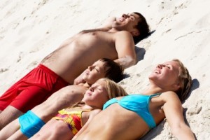 picture of family sunbathing on beach father mother son daughter