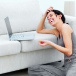 picture of Closeup of a happy young lady sitting on floor with laptop on sofa
