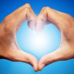 picture of hands in heart loving sign towards sun 