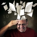 picture of Conceptual image of papers coming out of a mans head with pain expression