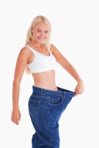 picture of Cute woman wearing to big jeans in a studio