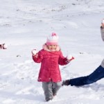 picture of Happy kids and woman playing in the first snow of winter 
