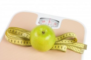 picture of Scale, tape and apple on white background