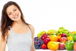 picture of Young smiling woman with fruits and vegetables. Over white background