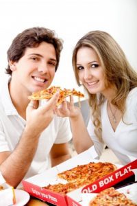 picture of couple eating pizza isolated over white 